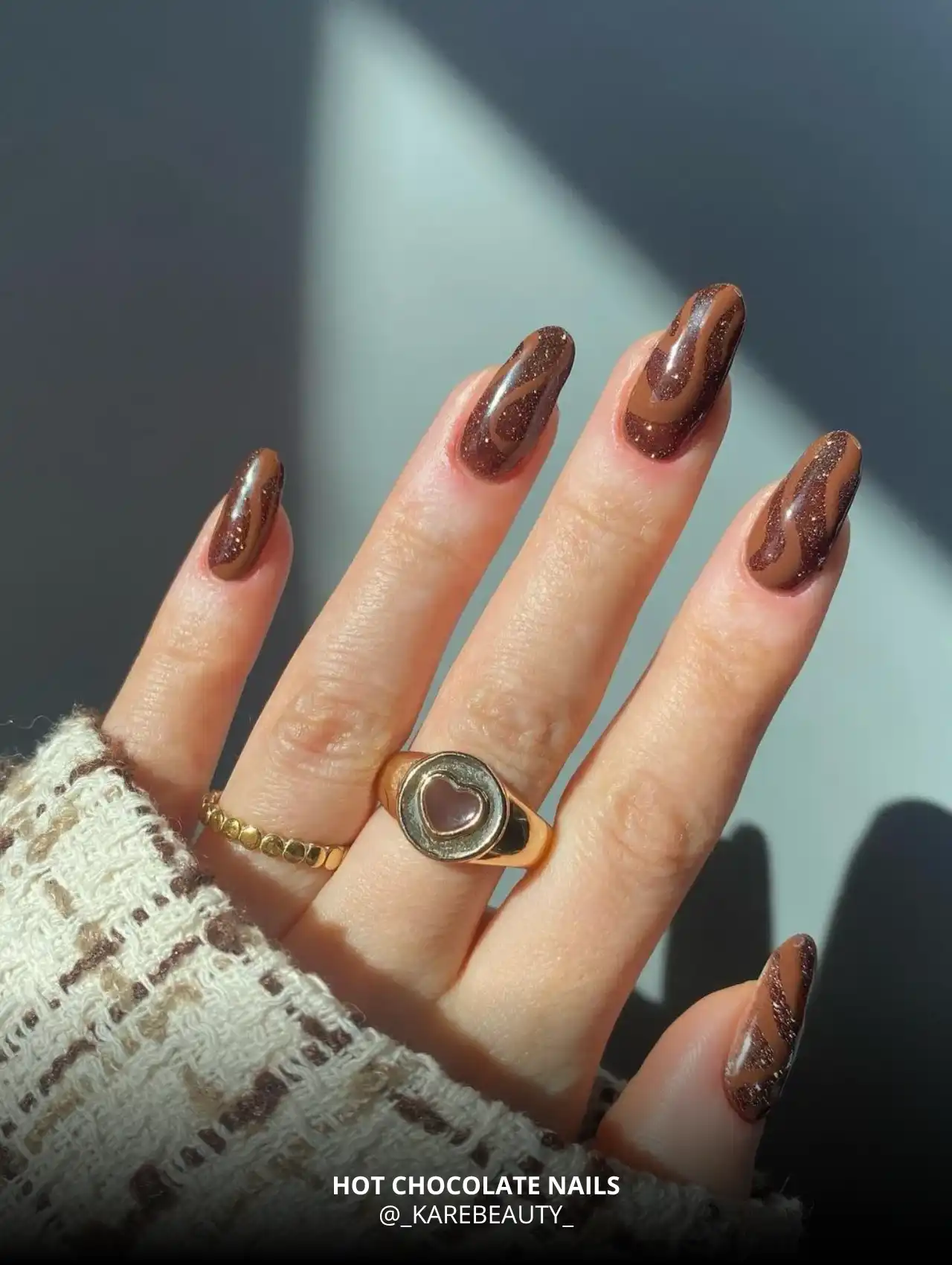 Hot chocolate fall nail design with glitter swirls.