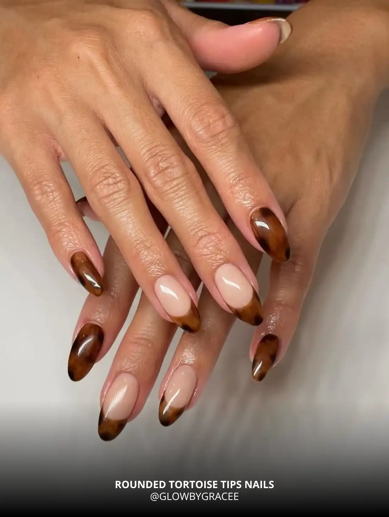 Rounded tortoise tips fall nail design in brown and amber shades.