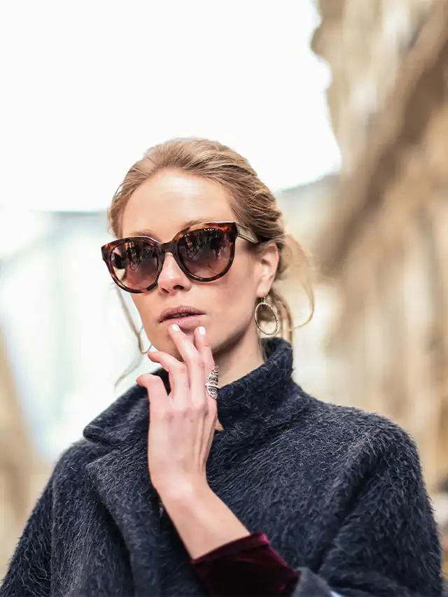 a woman wearing sunglasses and a black coat