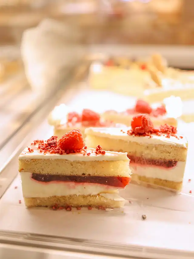 a piece of cake with raspberries on top