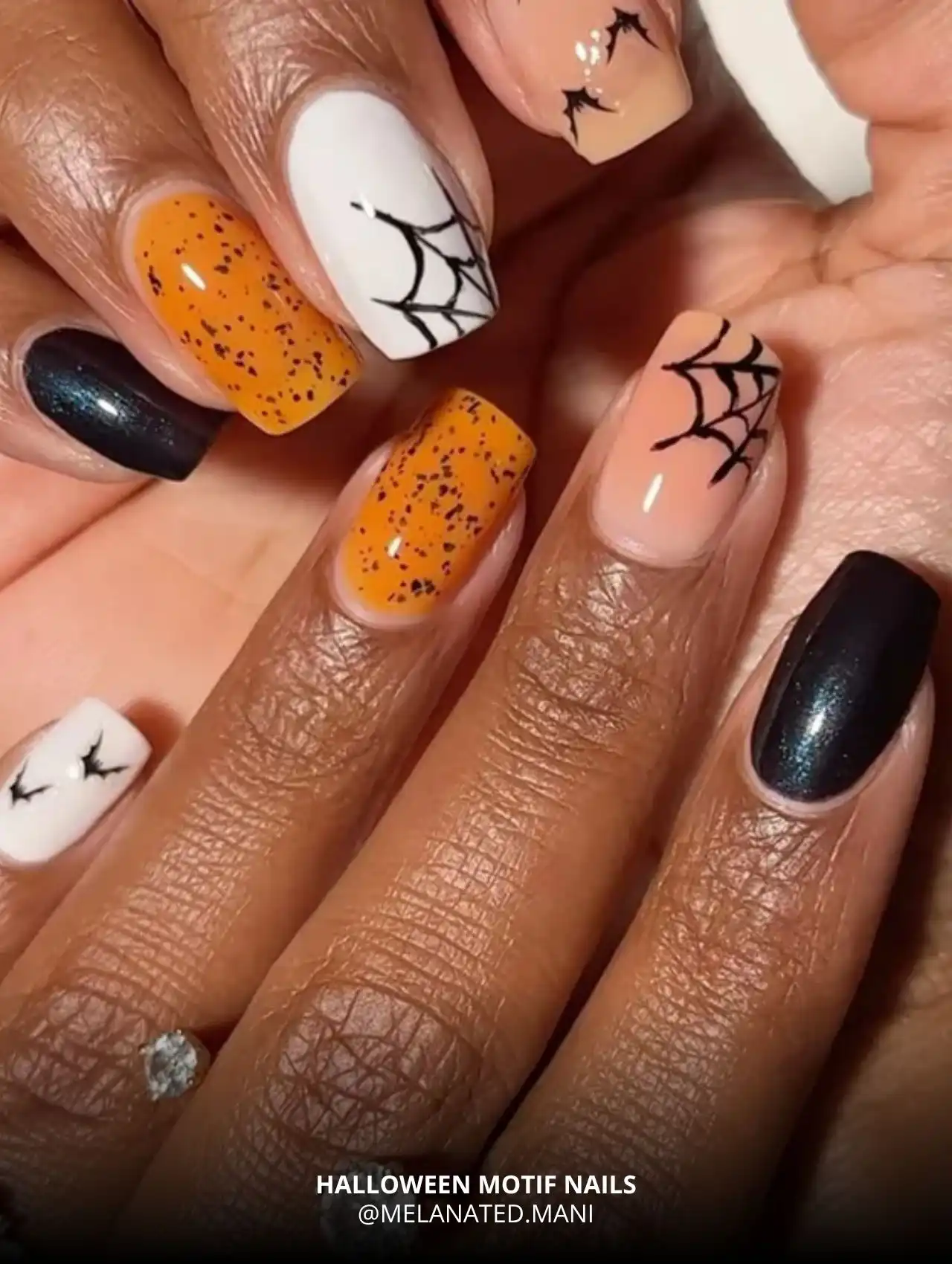 Halloween motif nails with orange, black, and spiderweb designs, trendy Halloween nails