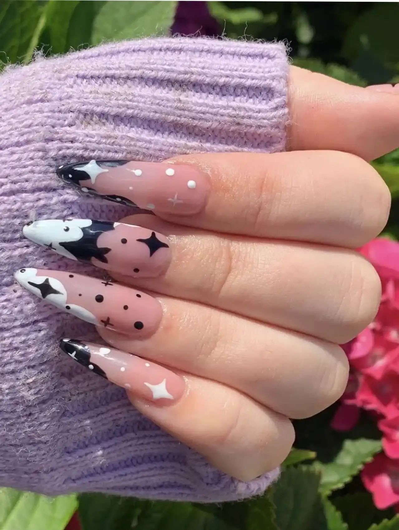 Minimalistic Halloween nails in black and white with bat and star designs.