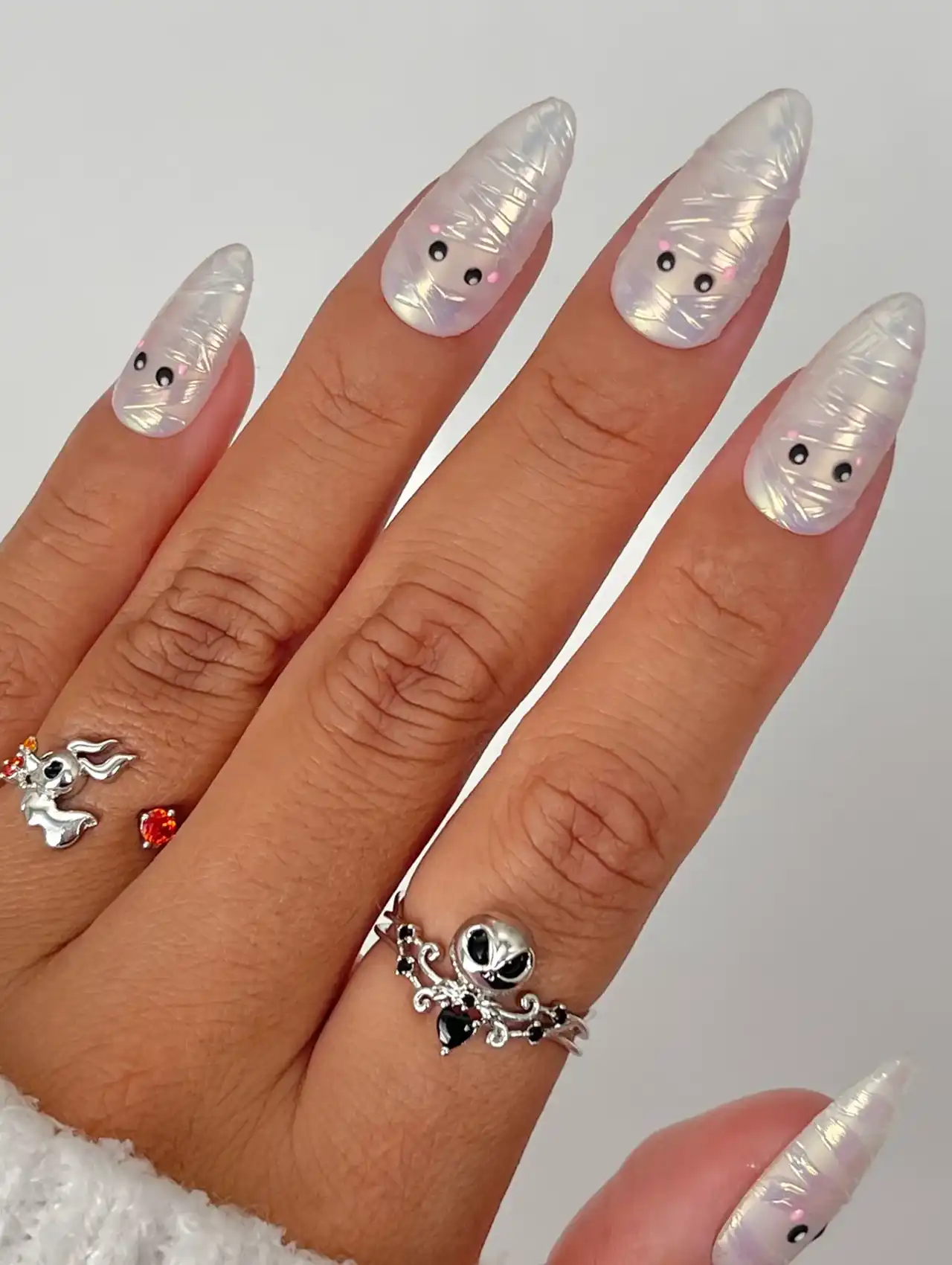 Minimalistic Halloween nails with chrome white mummy wrap design and cute black eyes.