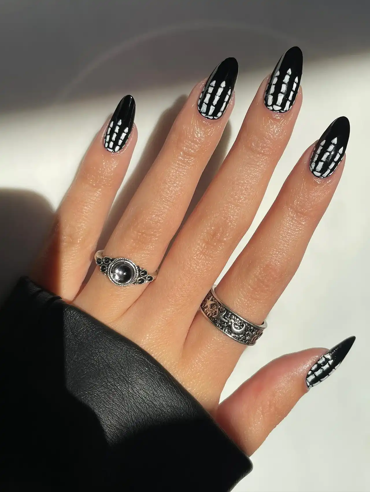 Minimalistic Halloween nails in neutral tones with subtle themed designs.