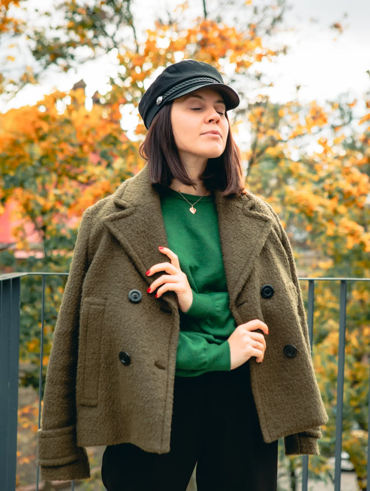 Mujer con abrigo verde y suéter, estilo ropa de invierno moderna al aire libre
