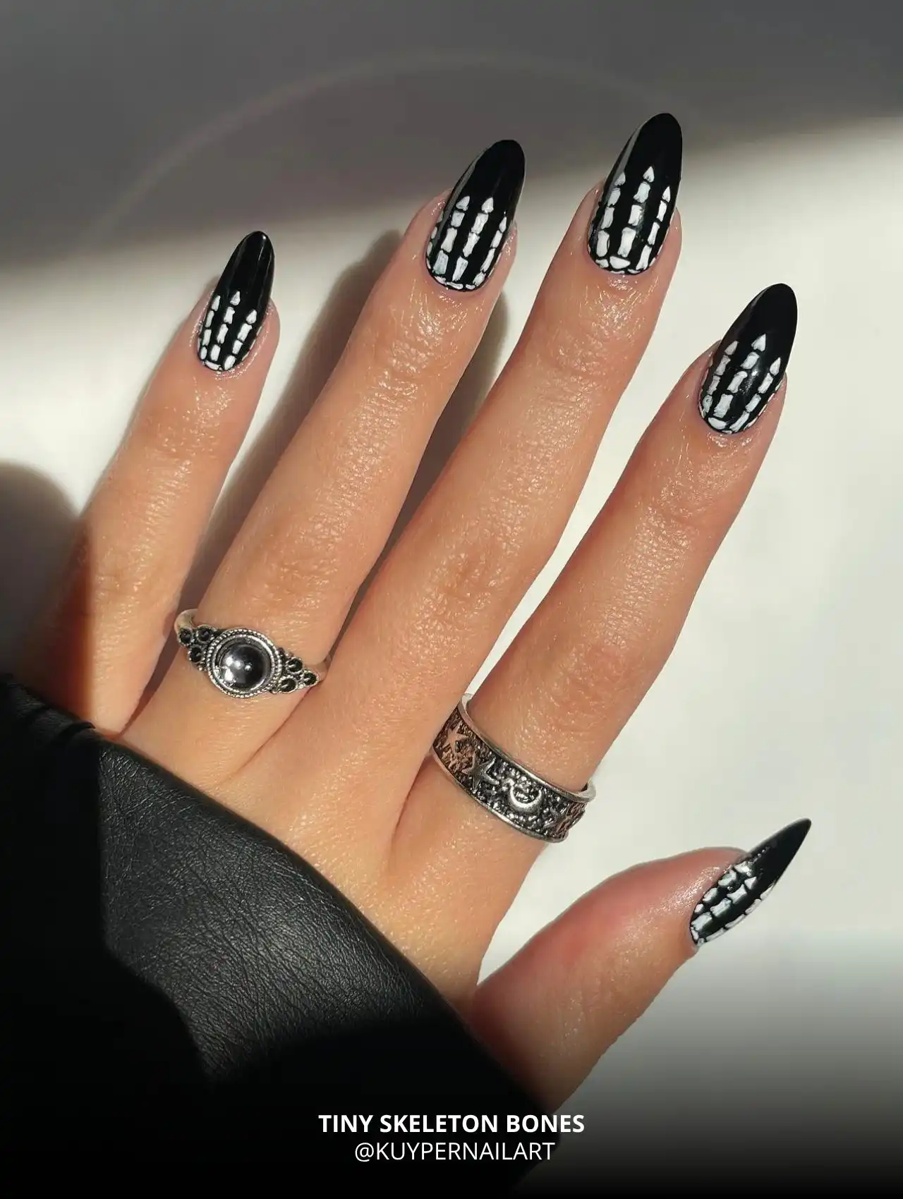 Black nails with white skeleton bones pattern, trendy Halloween nails