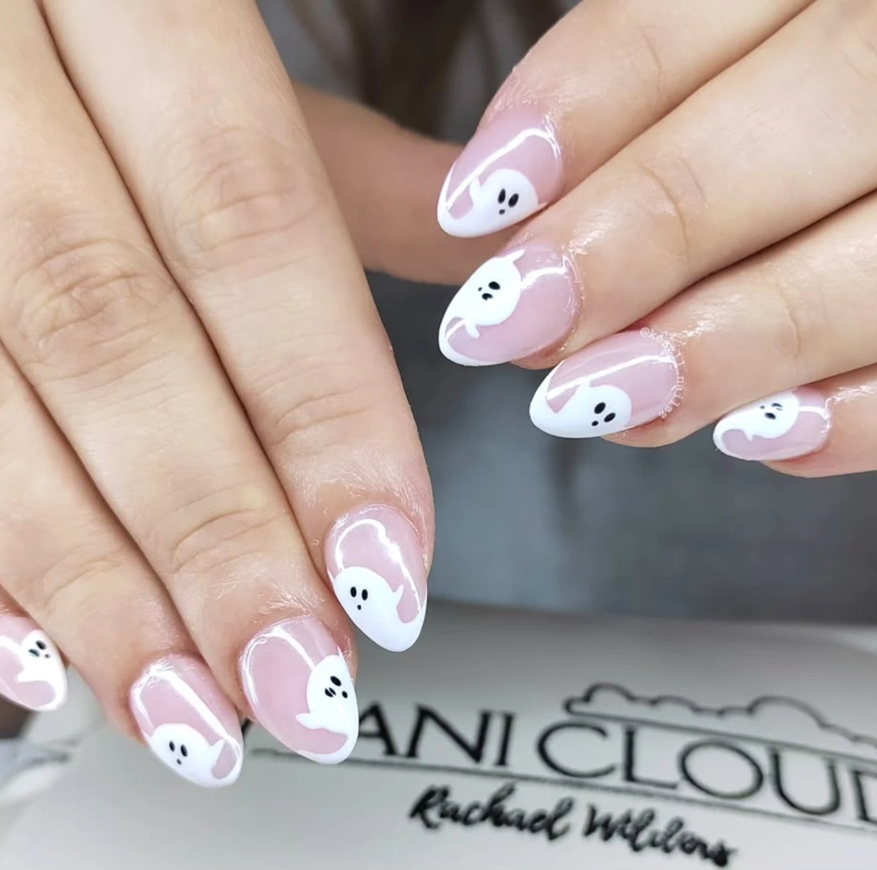 Diseño de uñas elegantes y sencillas con fantasmas blancos sobre base rosa translúcida.