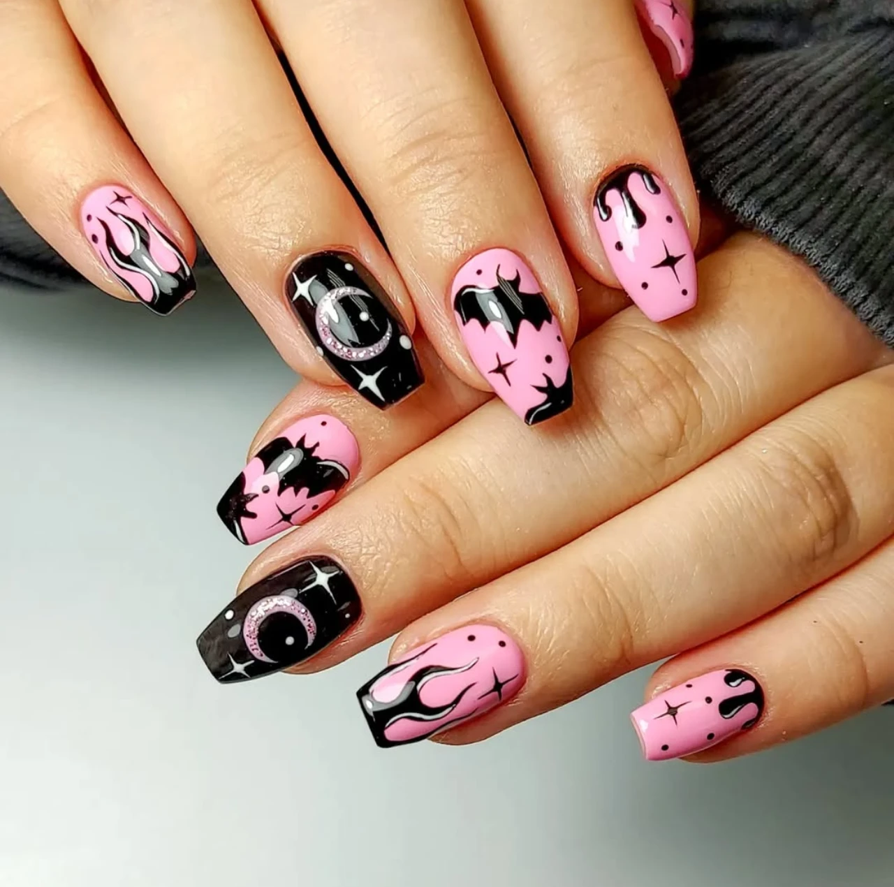 Diseño de uñas elegantes y sencillas estilo francesas con glitter rosa y murciélagos.