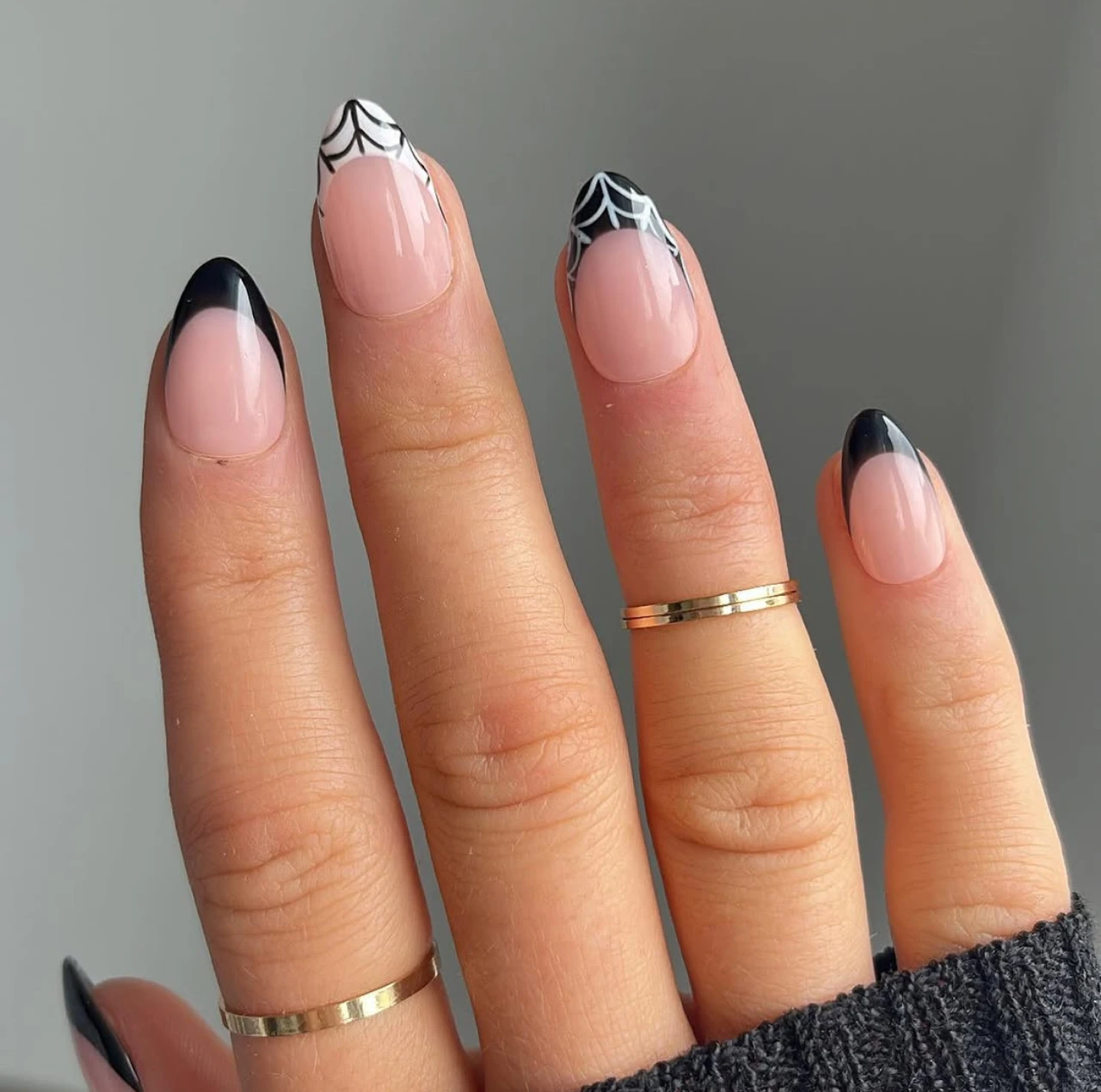 Diseño de uñas elegantes y sencillas estilo francesas con telaraña blanca y negra.