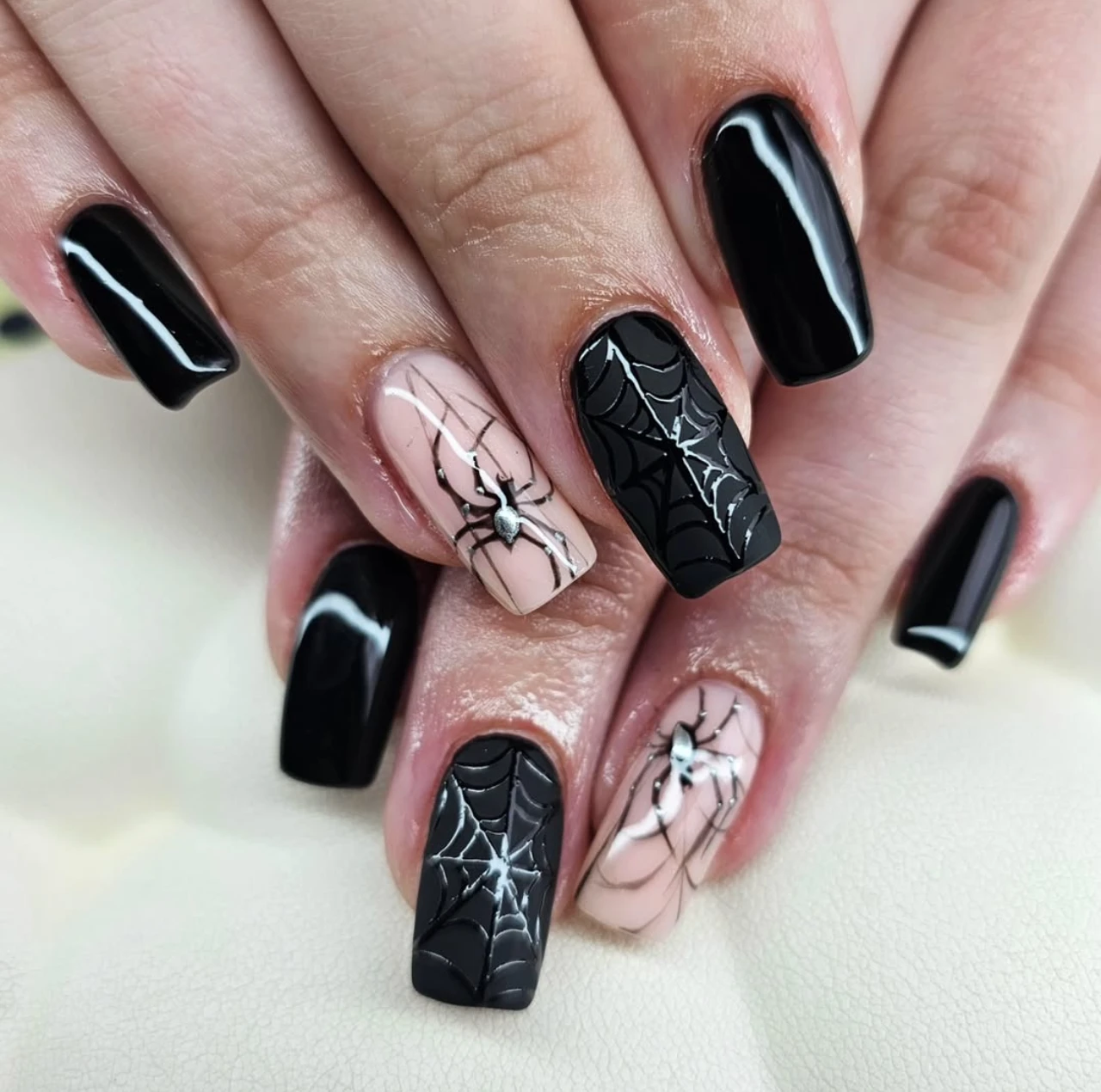 Diseño de uñas elegantes y sencillas con telarañas y arañas para Halloween.