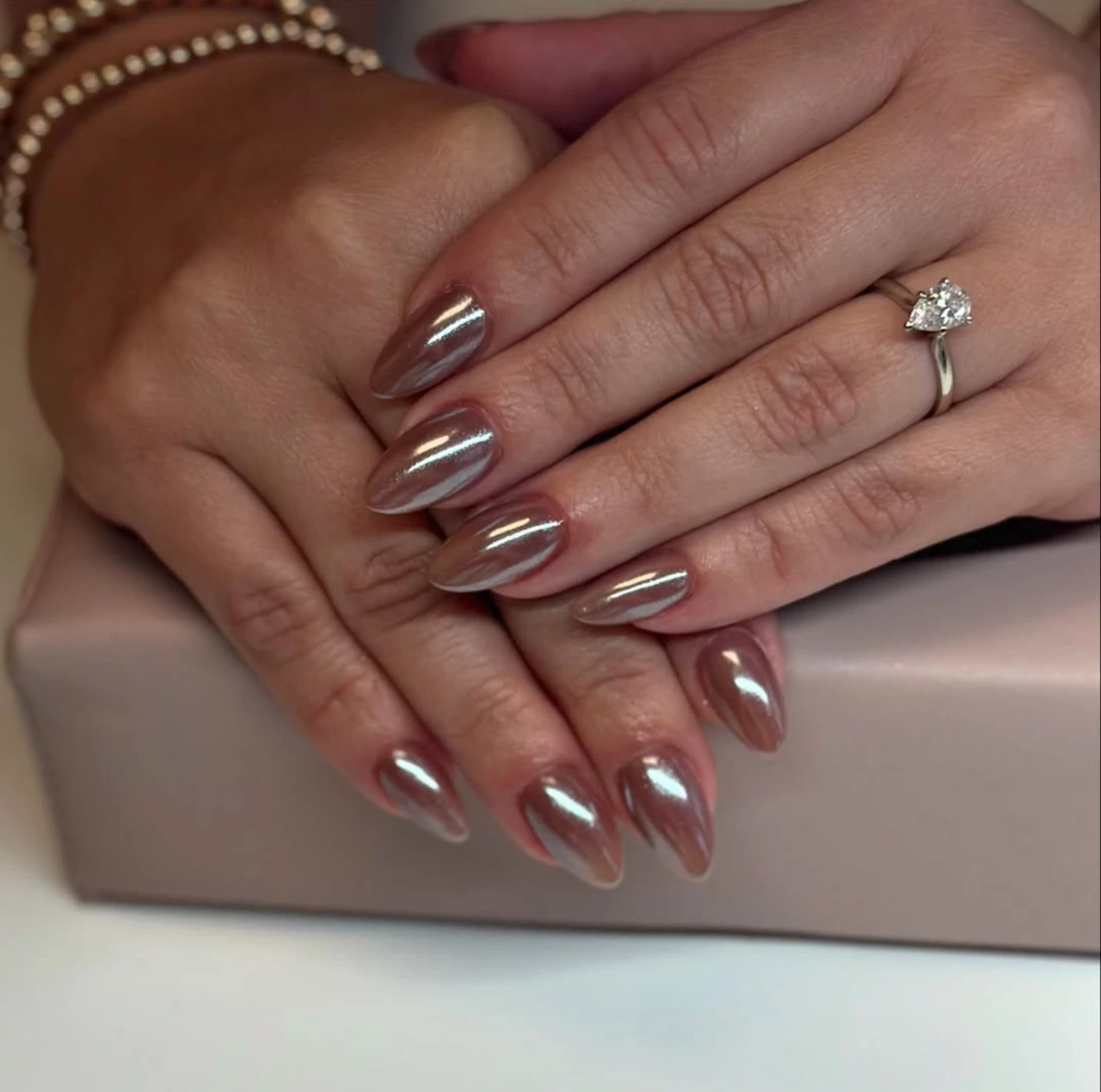 Uñas en tendencia otoño con acabado café cromado brillante y elegante.