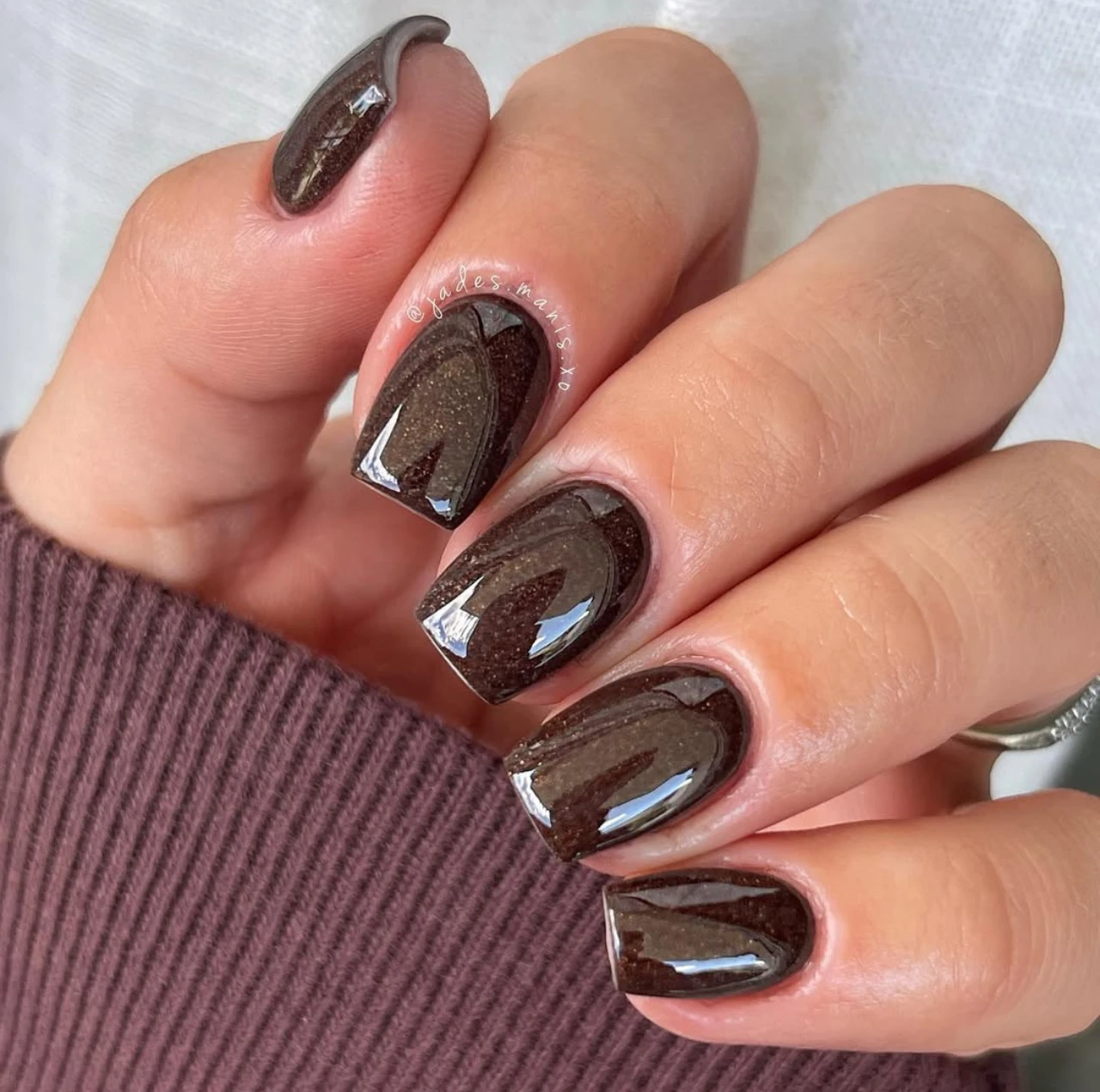 Uñas en tendencia otoño tono espresso con glitter y diseño brillante moderno.