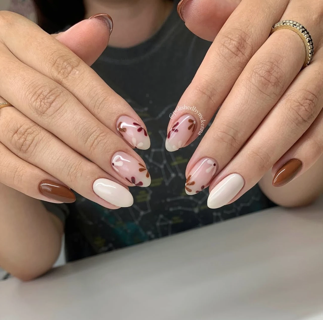 Uñas en tendencia otoño floreadas con diseño de hojas pequeñas en tonos tierra.