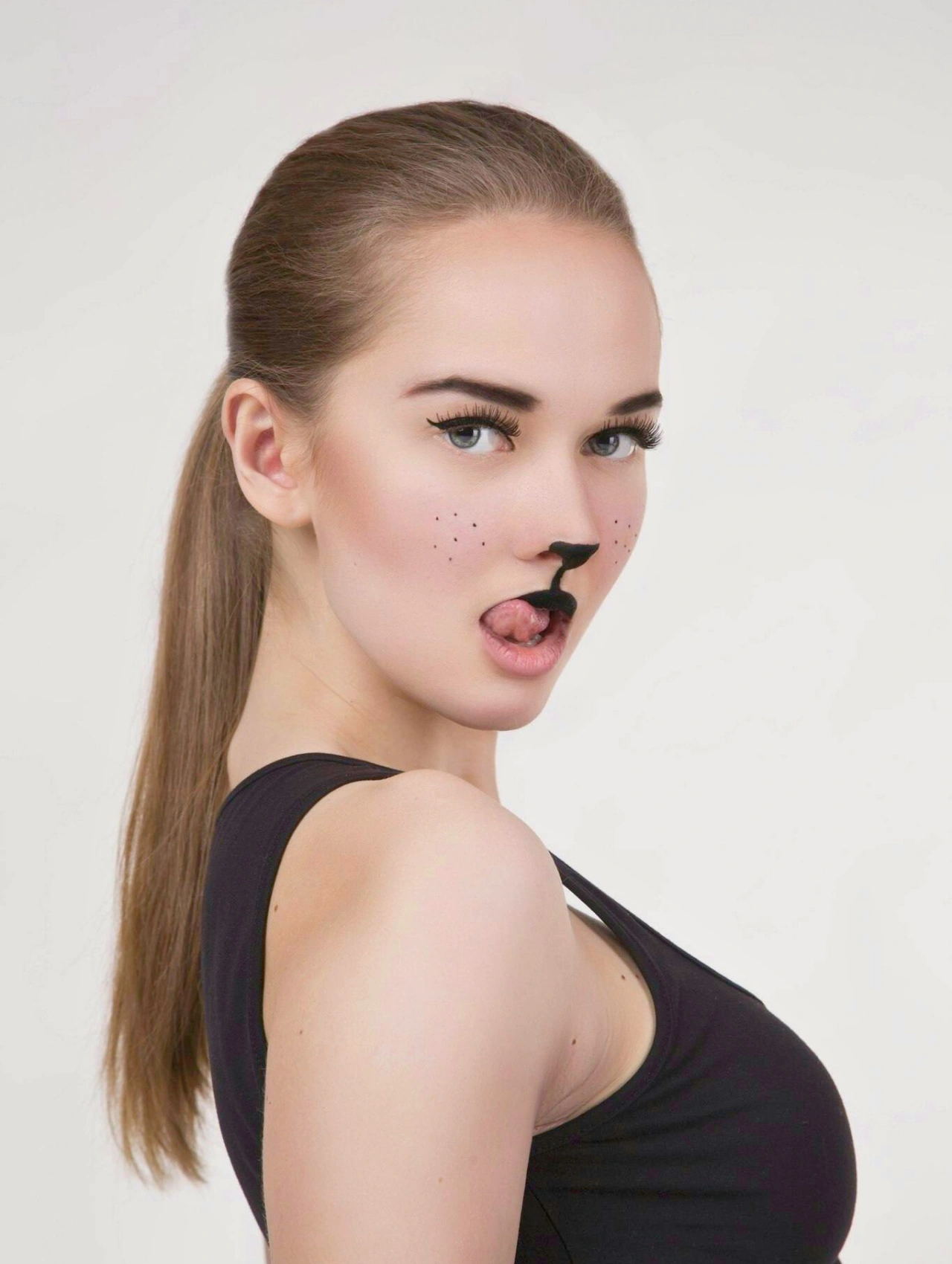 Maquillaje de gato sutil y elegante con nariz negra y delineado fino, ideal para un look felino moderno.