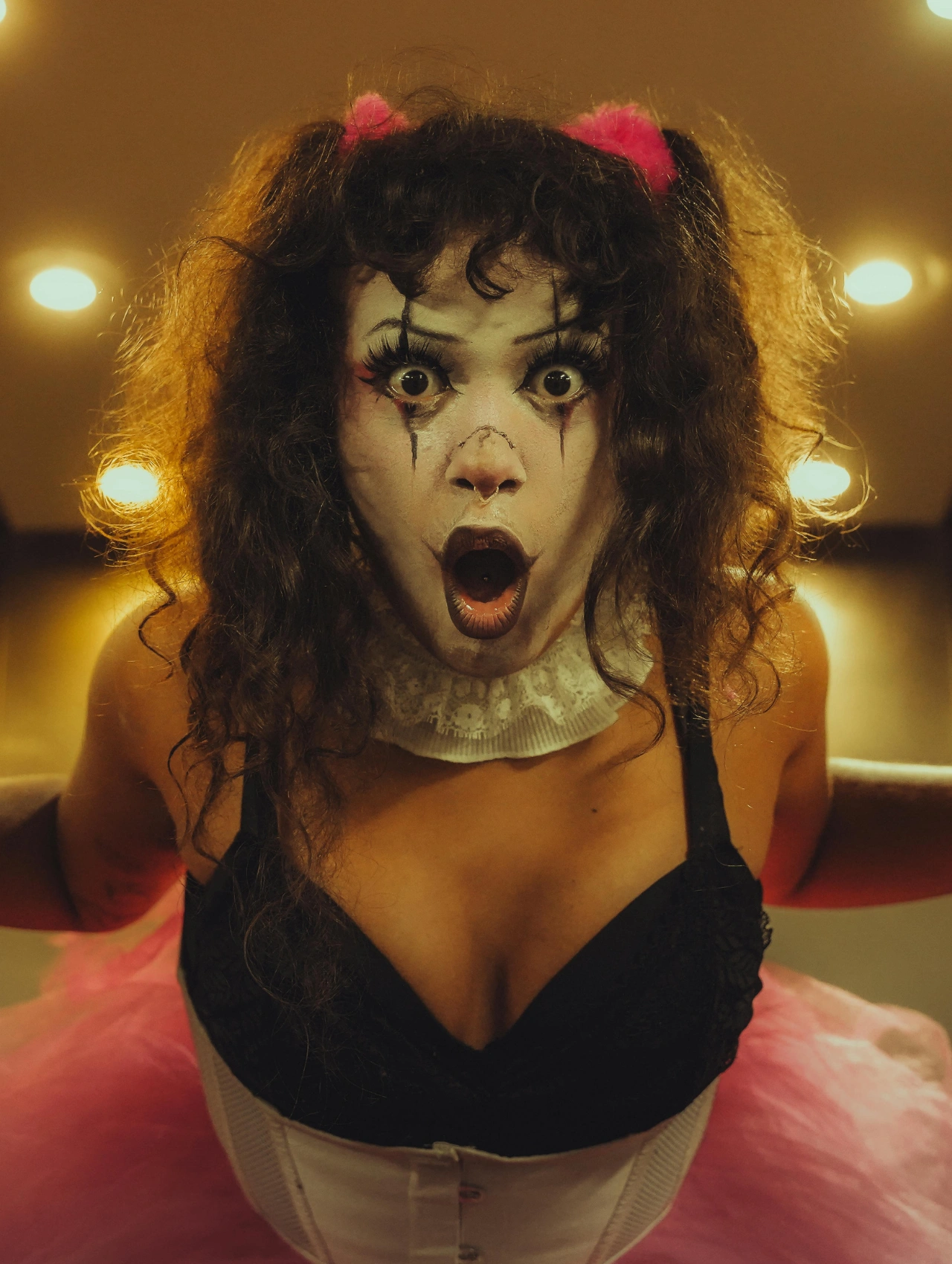 Maquillaje de payaso creativo para Halloween con expresión dramática y detalles artísticos en blanco y negro.
