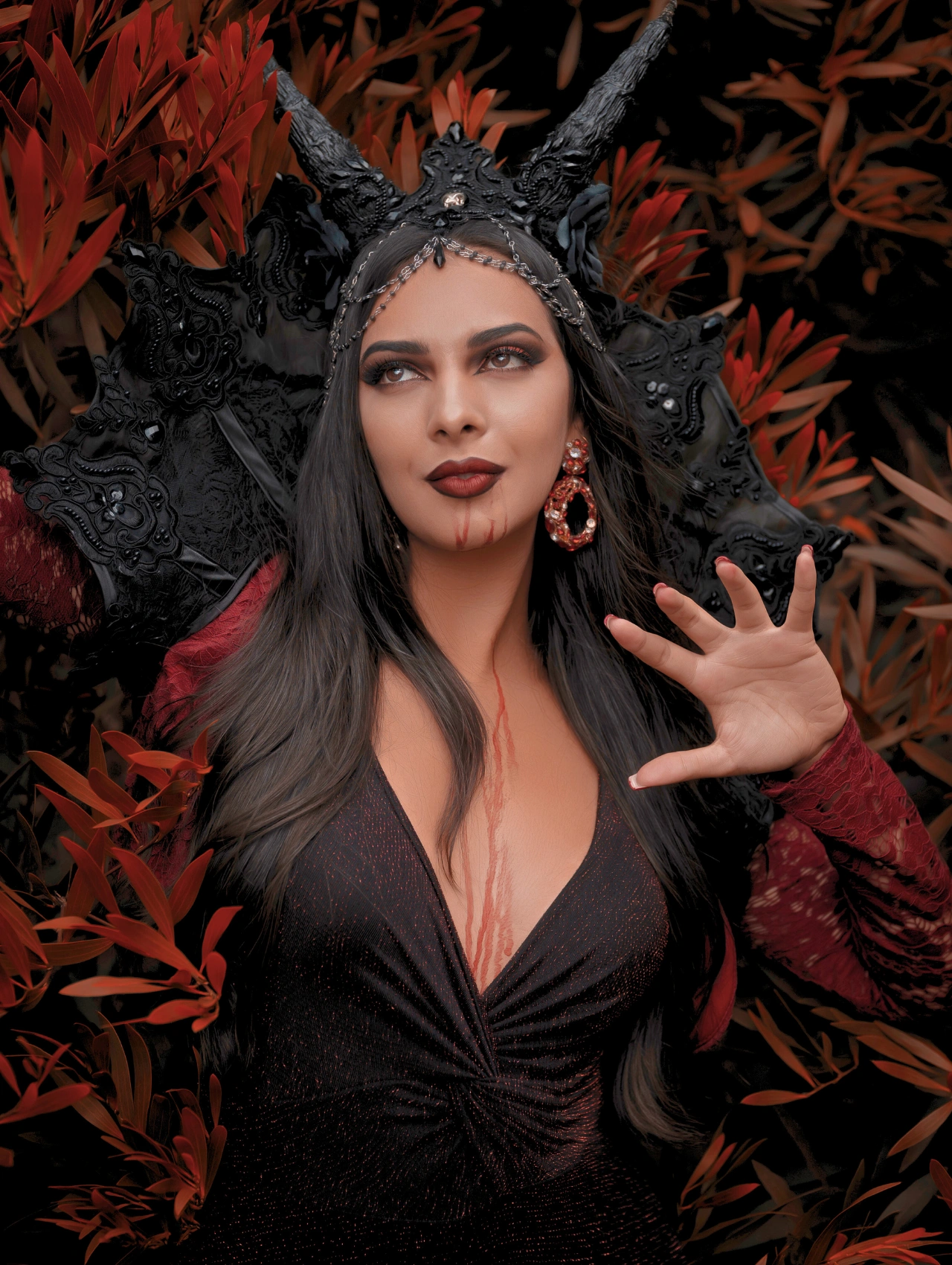 Maquillaje de vampiro con detalles en negro y sangre falsa, look gótico entre naturaleza y oscuridad.