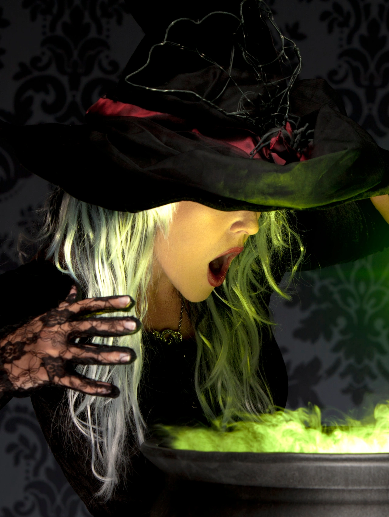 Maquillaje de bruja con luz verde mágica y expresión dramática, estilo clásico de Halloween.