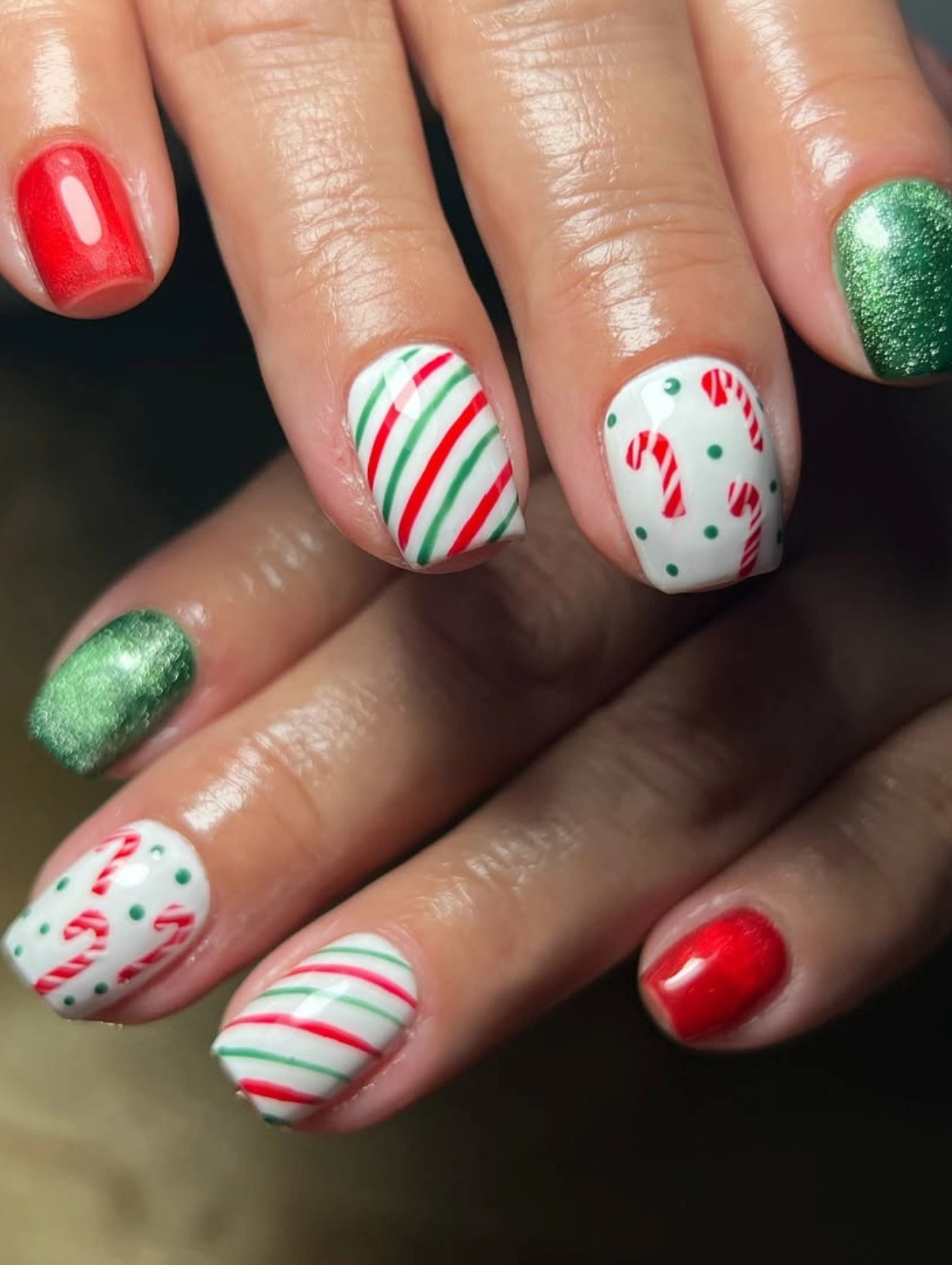 Diseños de uñas para invierno con bastones de caramelo y rayas festivas en rojo y verde