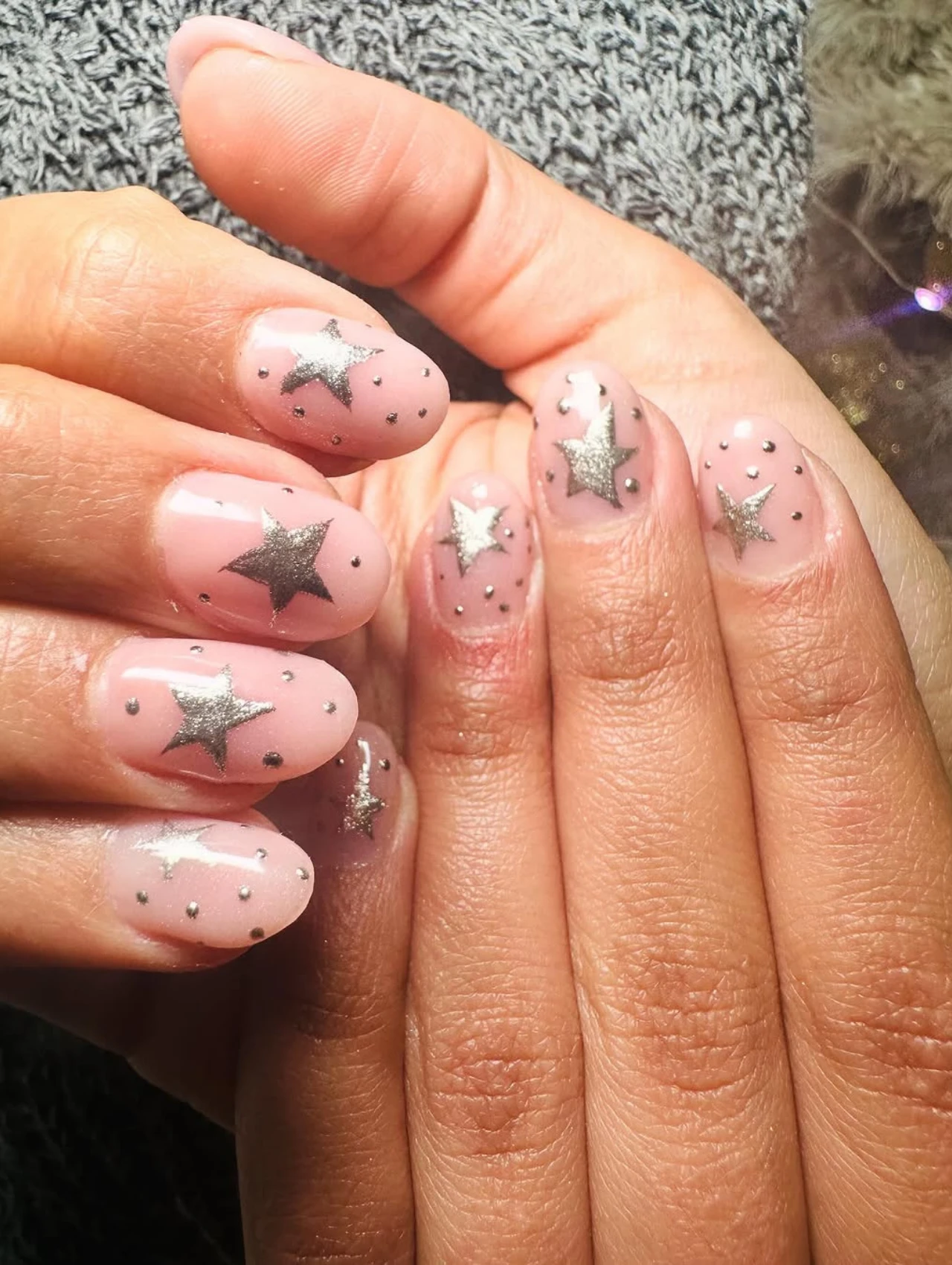 Diseños de uñas para invierno con fondo nude y estrellas plateadas
