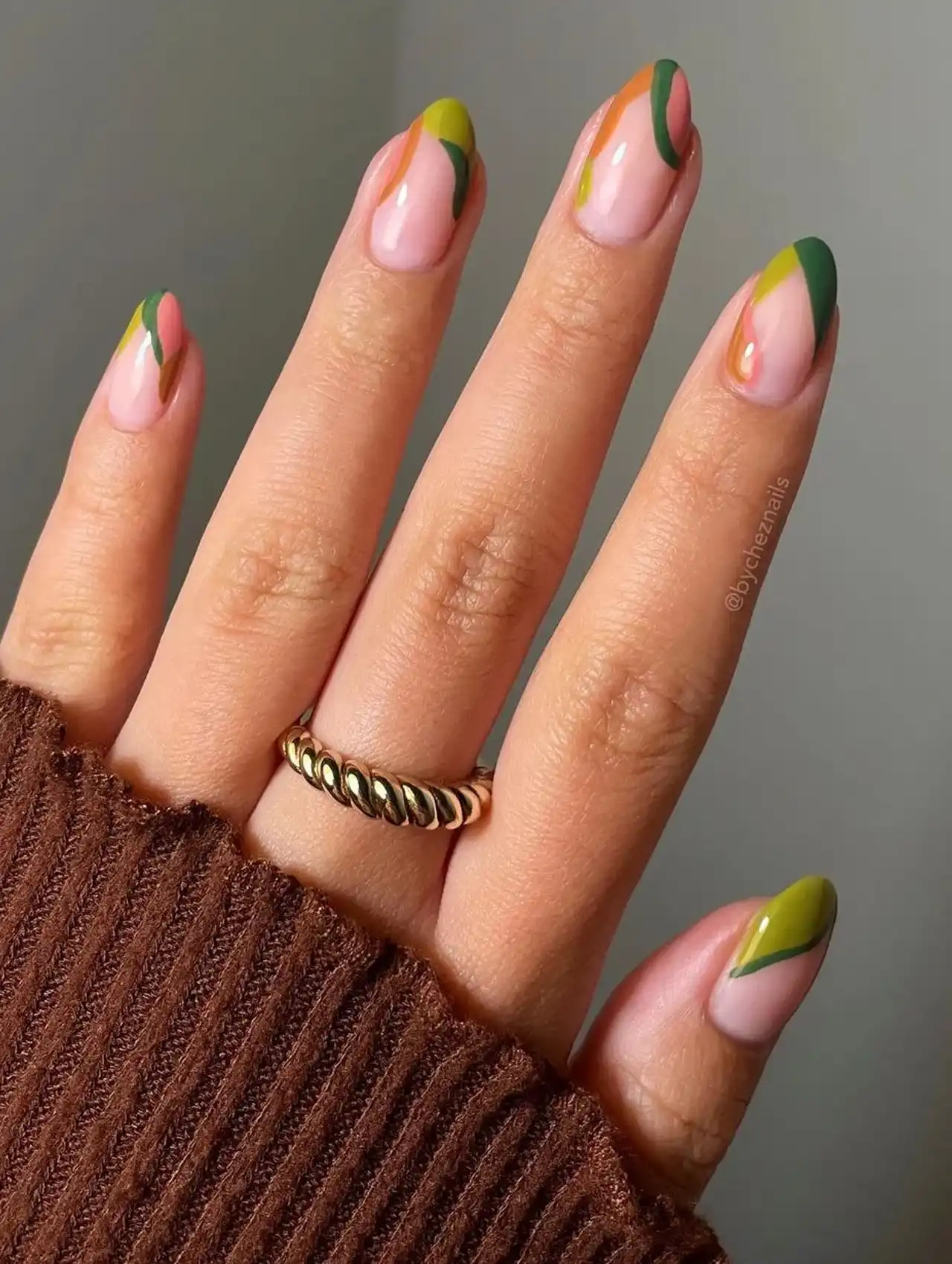 Art inspired november nail design with green, orange, and mustard swirl tips