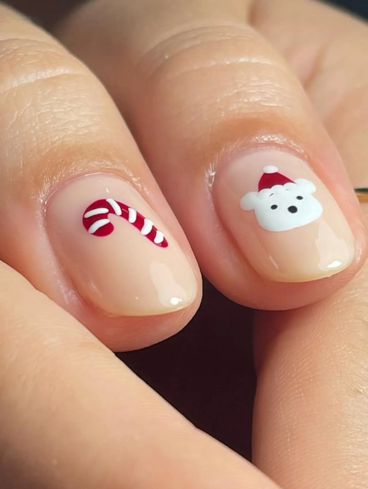 Diseños de uñas para invierno con bastón de caramelo y osito navideño