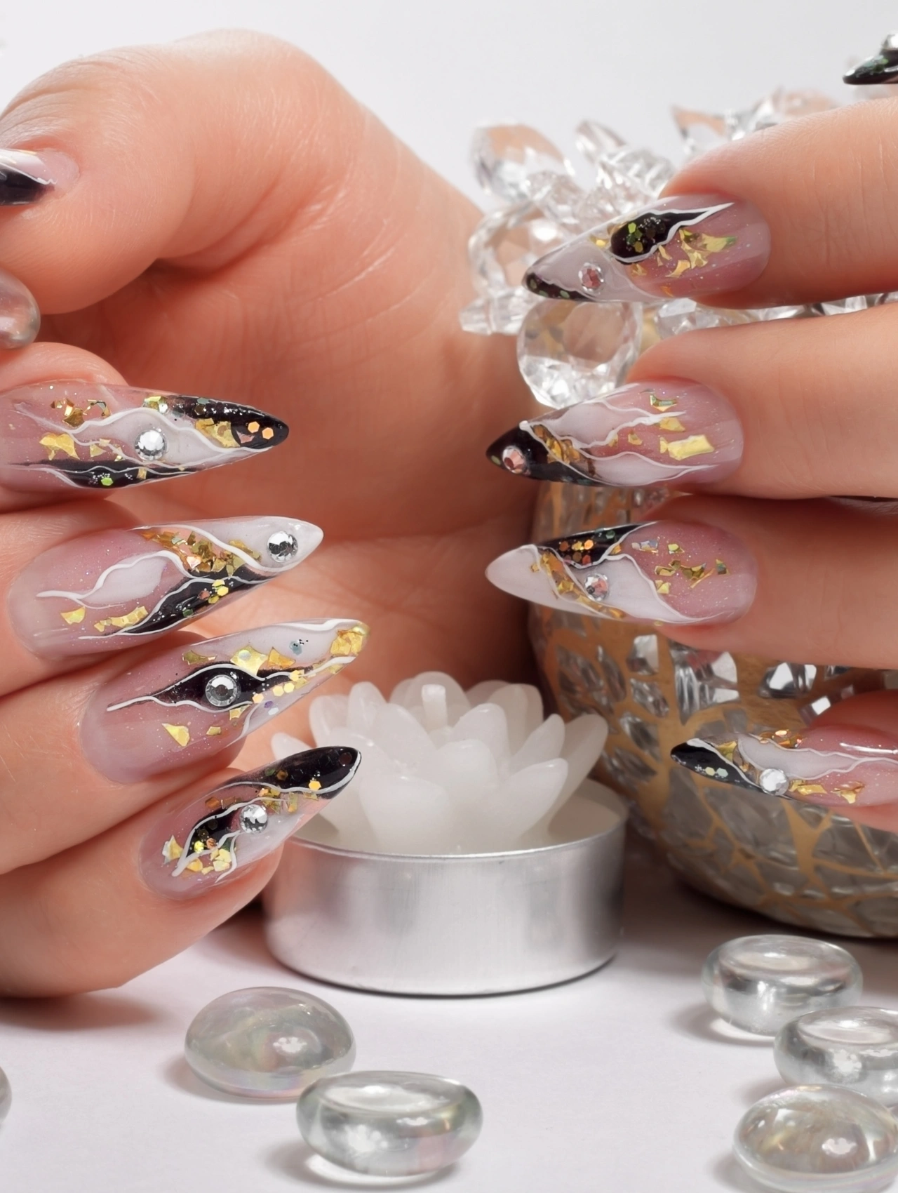 Christmas Nail Trends featuring long stiletto nails with black, gold, and silver abstract holiday art.