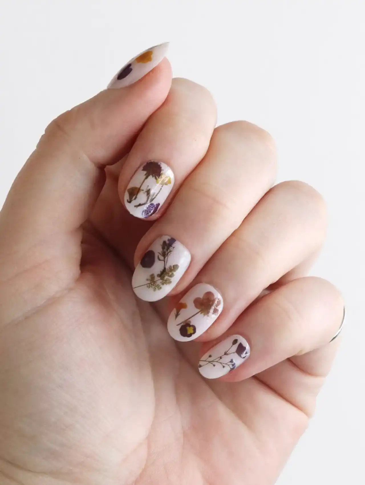 Thanksgiving nails with nude base and dried floral accents