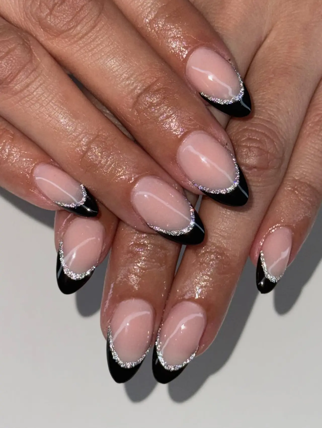 Diseños de uñas para invierno con francés negro y glitter plateado