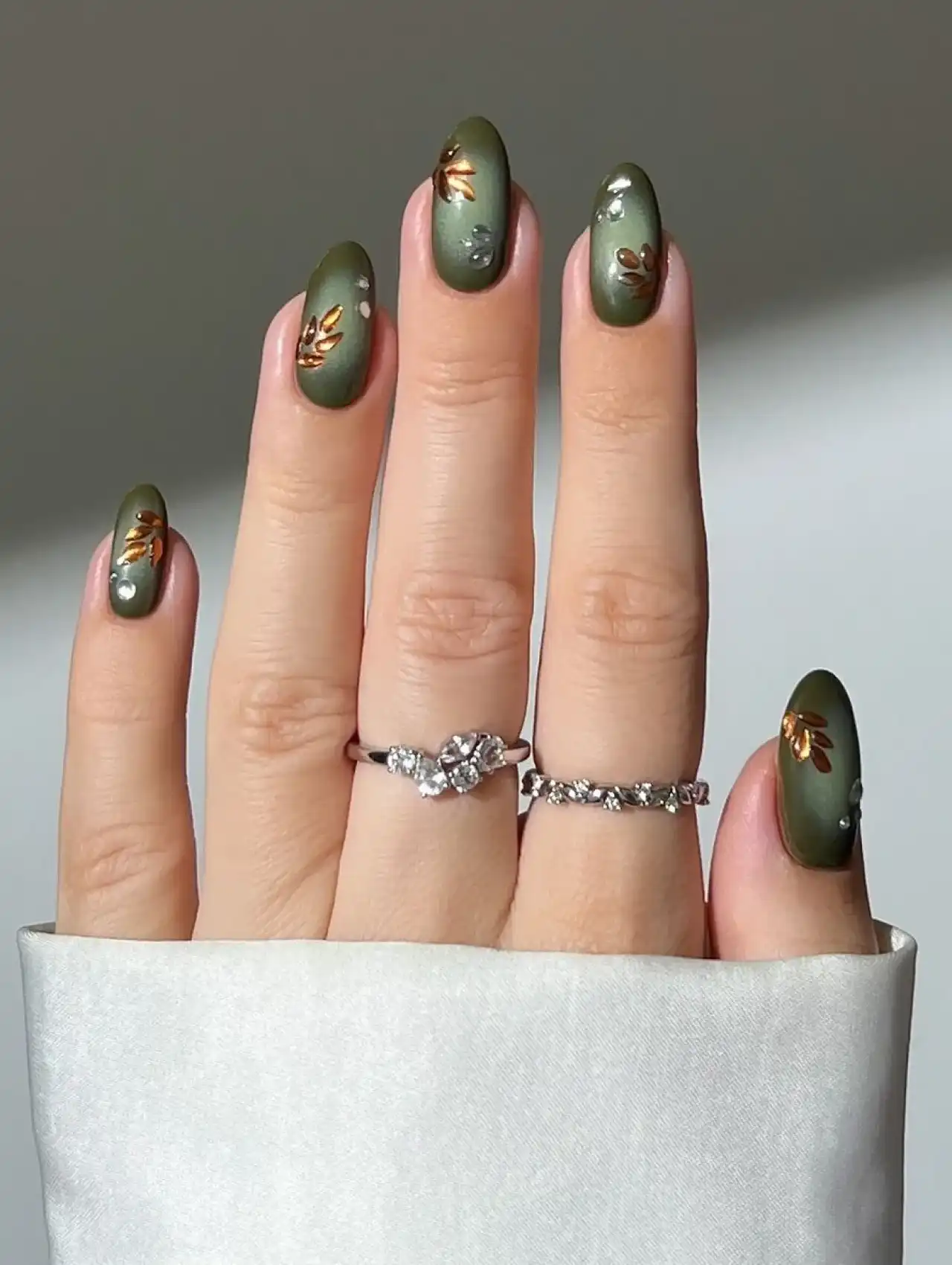 Green Thanksgiving nails with gold leaf accents and pearl details