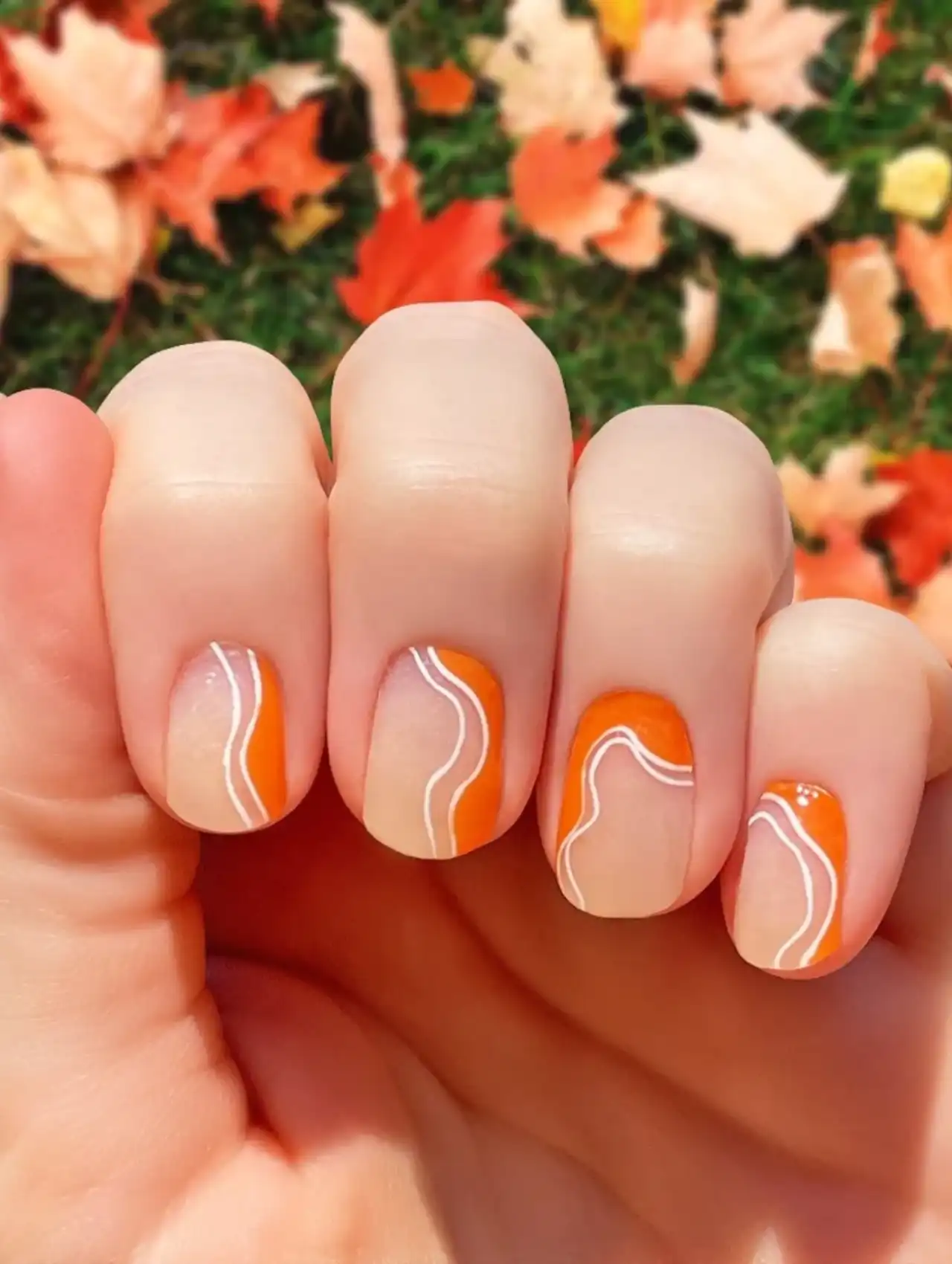 Groovy orange Thanksgiving nails with wavy retro lines