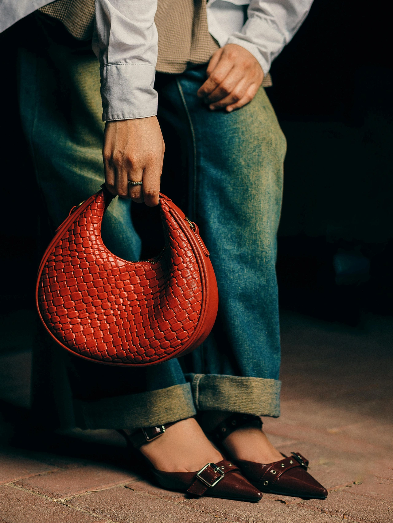 Mujer caminando con un look moderno y cálido, mostrando los mejores outfits para invierno con botas altas y suéter oversize.