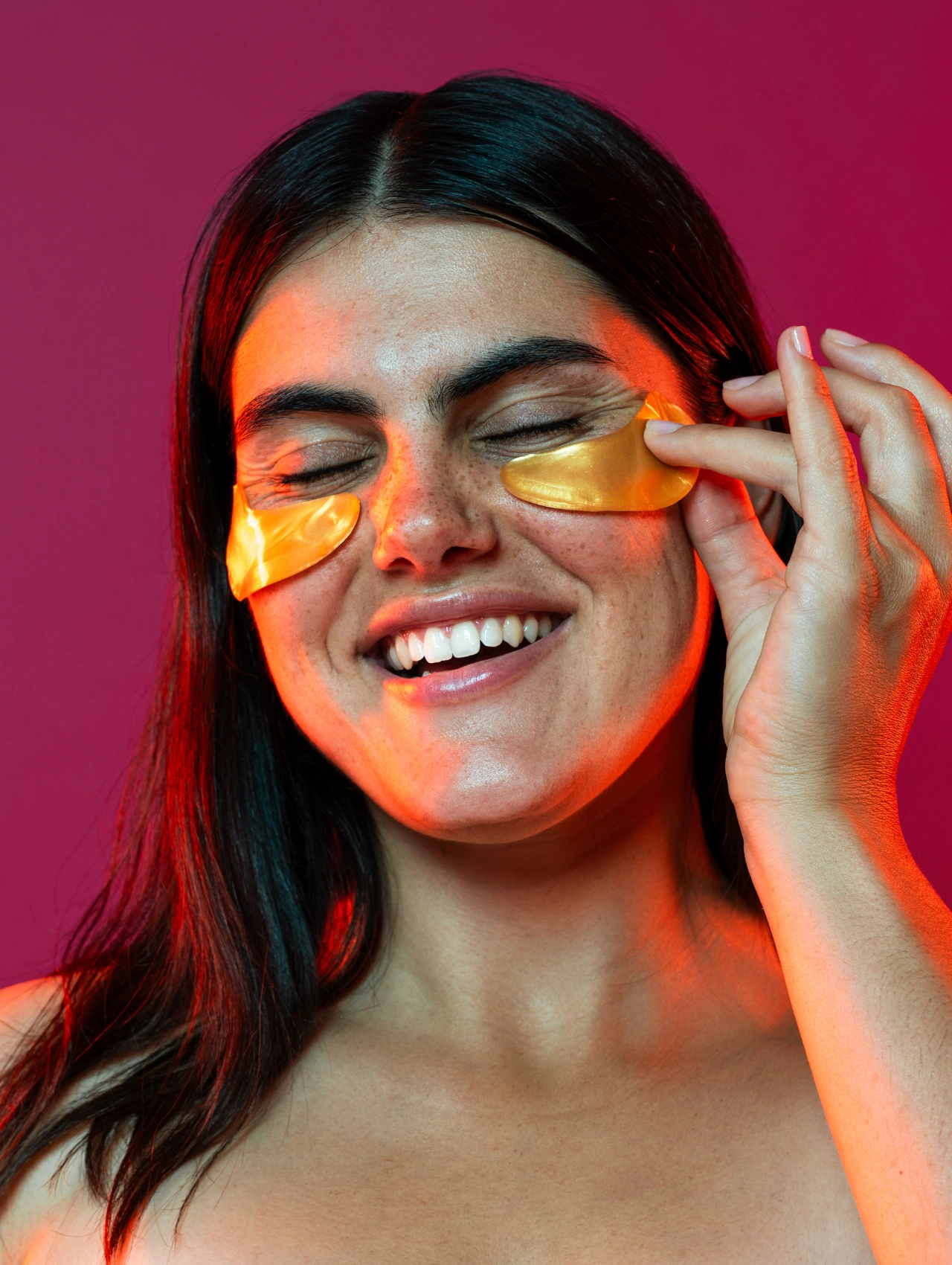 Mujer aplicando parches dorados en los ojos, idea de autocuidado dentro de Cosas para pedir en Navidad.