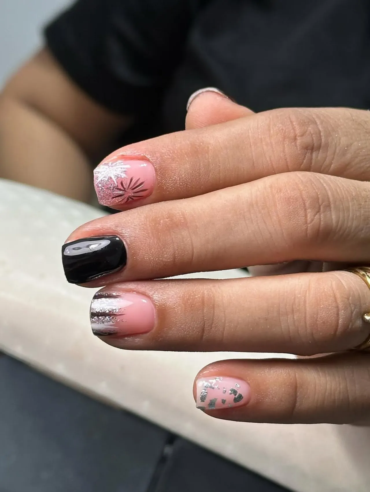 Diseño de uñas para invierno con glitter metálico y tonos rosa y negro