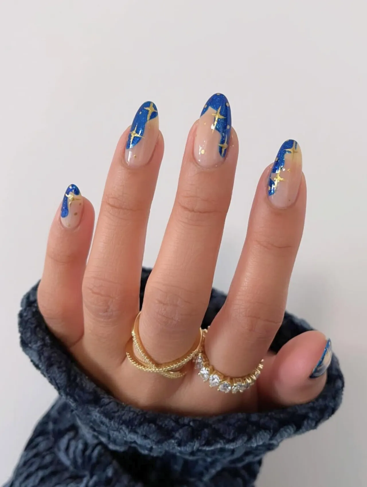Diseños de uñas para invierno inspirados en Hanukkah con estrellas doradas