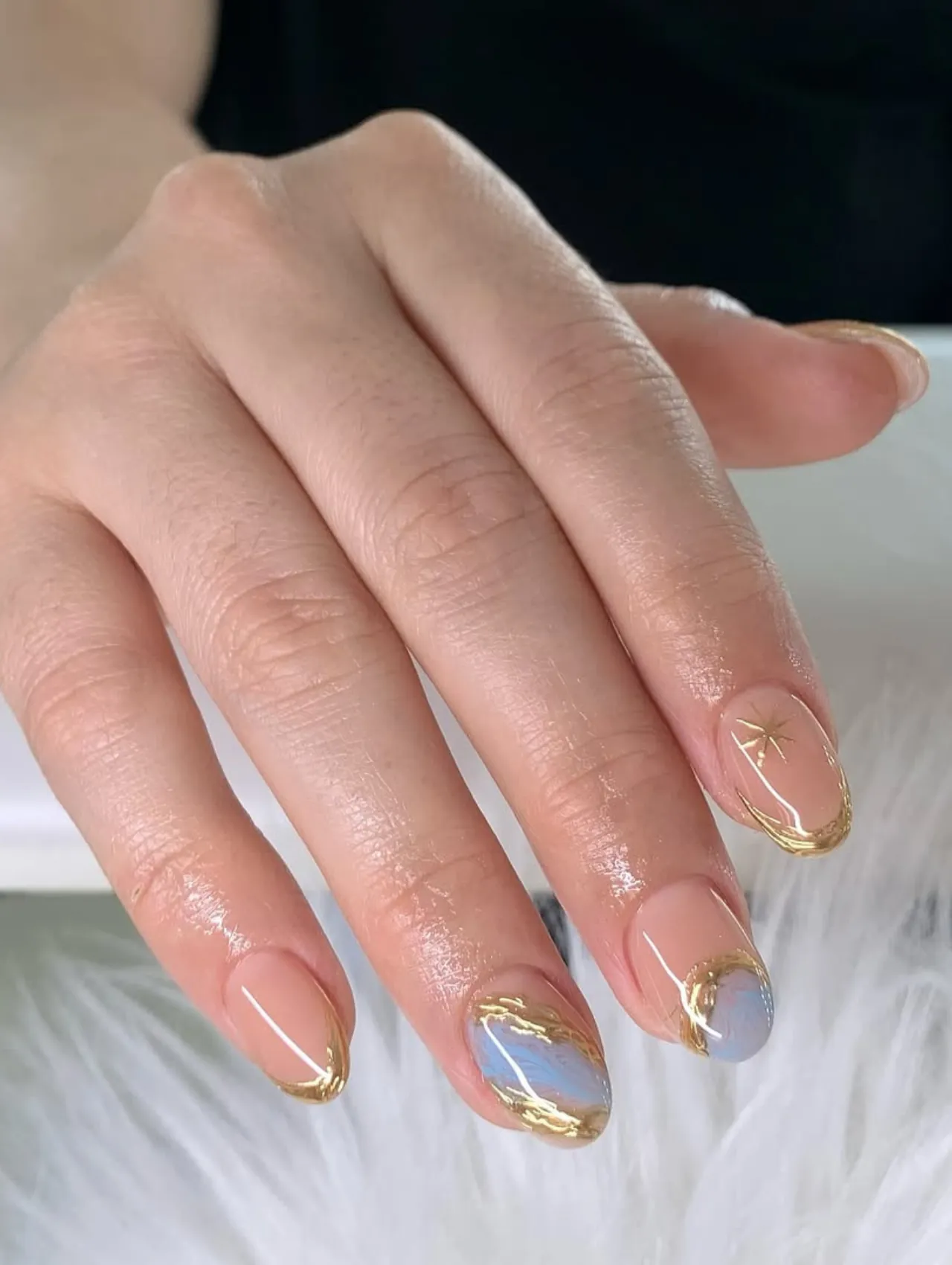 Diseños de uñas para invierno con arte abstracto en tonos nude y dorado