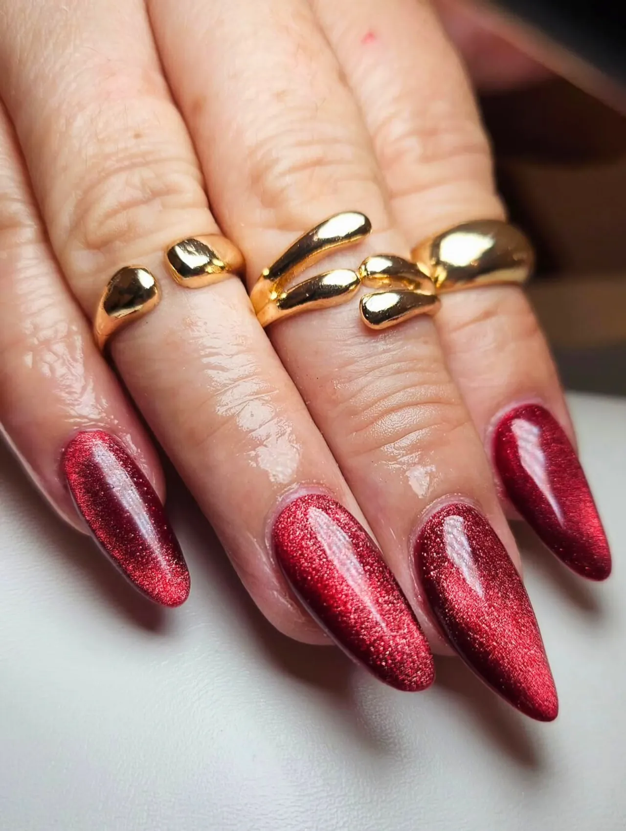  Diseños de uñas para invierno rojas con efecto destellante y forma almendrada