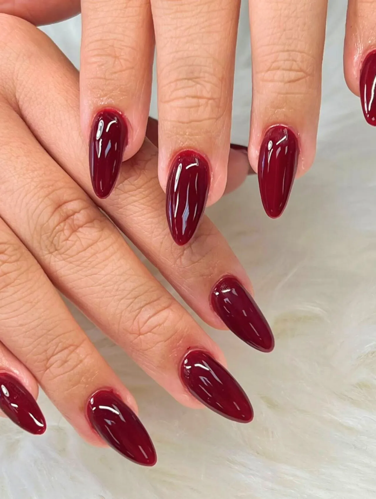 Diseños de uñas para invierno en tono rojo oscuro elegante