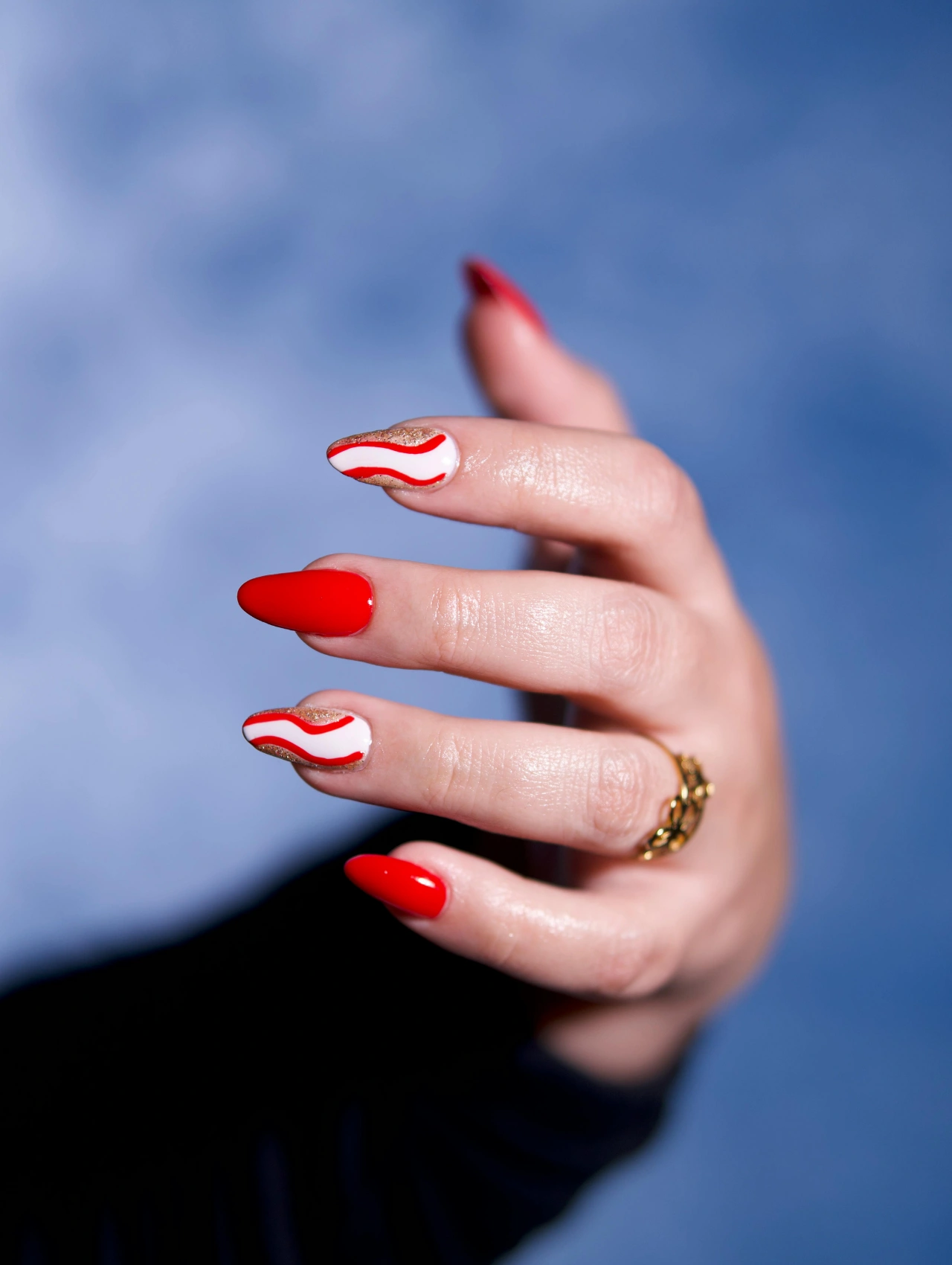Candy Cane Christmas Nails featuring red glossy polish with white peppermint wave accent design.