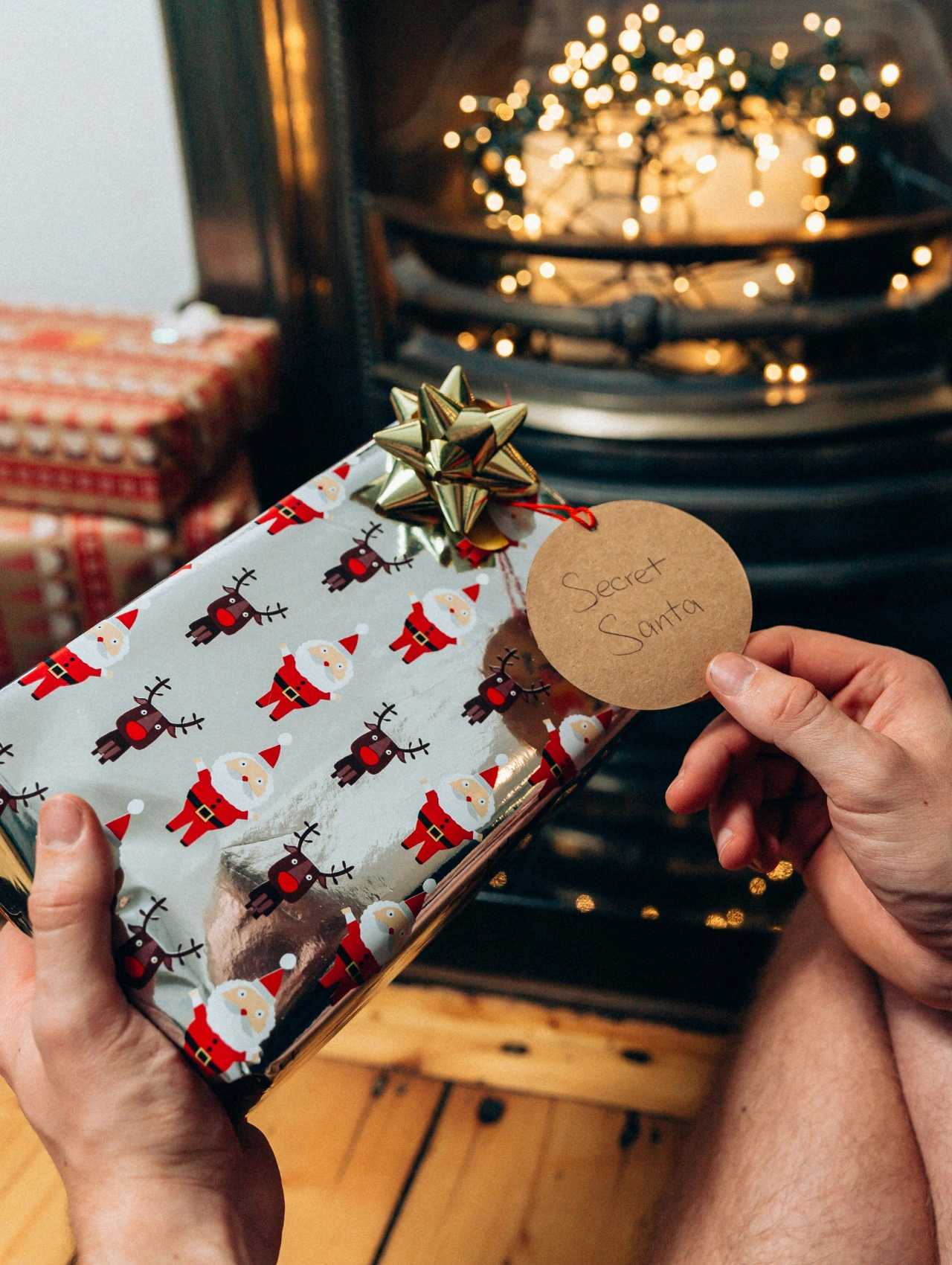 Regalo envuelto con papel navideño frente a la chimenea, ideal como inspiración para detalles para amigo secreto.