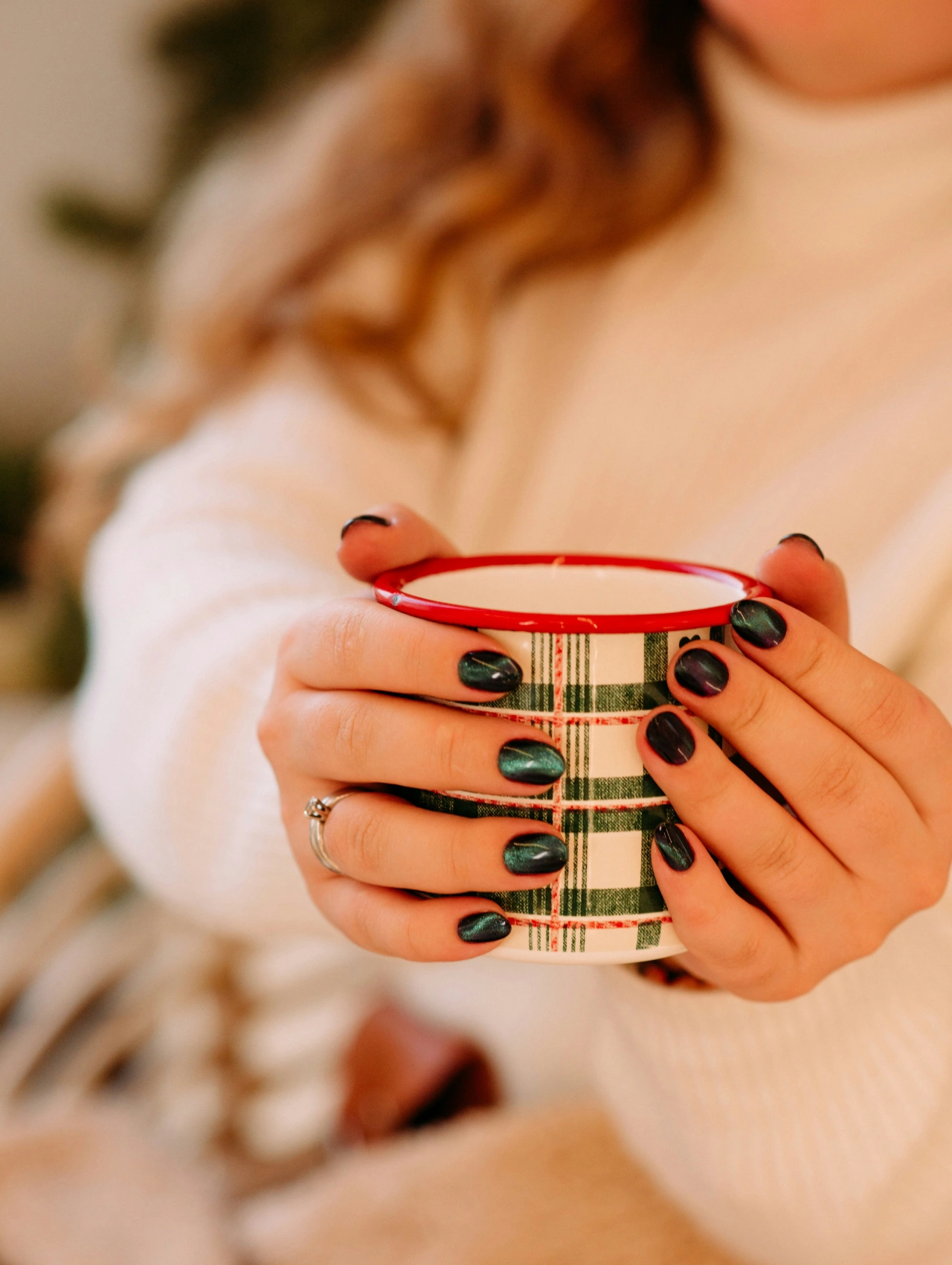 Modern Christmas nail design featuring shimmering green nails holding a holiday mug.