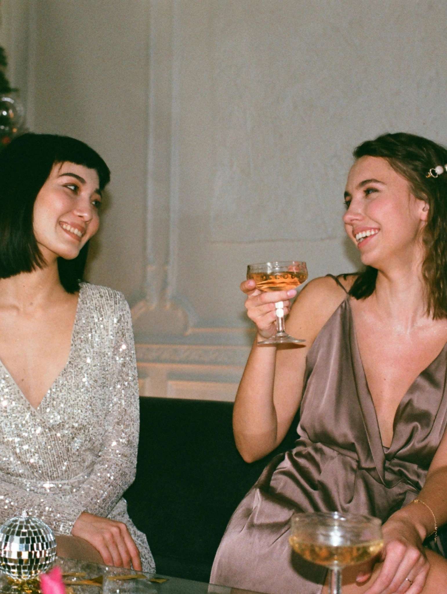 Outfit navideño con vestido elegante y copa en mano siguiendo las tendencias que dominarán esta temporada festiva.