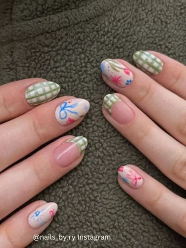 Close-up of hands displaying nails with alternating designs of soft plaid and delicate floral patterns.