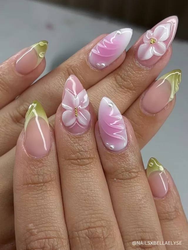 A mesmerizing nail design featuring 3D pink and white butterfly accents, soft green French tips, and pearl embellishments on almond-shaped nails.