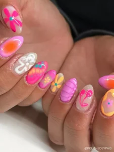 A vibrant and playful neon nail design featuring a mix of bold floral patterns, gradient effects, and intricate details.