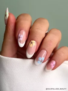 A chic French manicure with pastel floral accents and rhinestone details, adding a fresh and feminine touch to a timeless nail design.