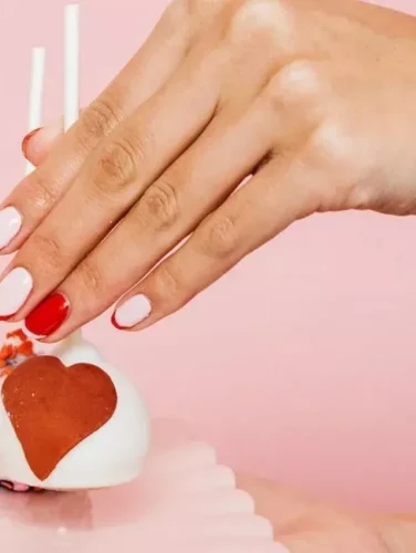 A chic and understated Valentine's nail design featuring a soft pink and white base with delicate red heart outlines and accents. The minimalist approach gives it an elegant yet playful touch, perfect for those who love a subtle yet romantic look. Ideal for pairing with cozy sweaters or a date-night outfit!