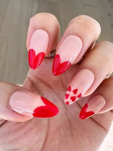 A romantic twist on classic French tips, this nail set features deep red heart-shaped designs at the tips, creating a bold yet elegant Valentine’s Day look. The accent nail adds a playful touch with tiny scattered hearts, enhancing the love-inspired theme. The glossy finish and almond shape elevate the style, making it a chic and flirty choice for any date night or celebration of love!