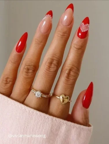 A chic and elegant take on classic French nails, this design features bold red tips with a glossy finish, accentuated by delicate pearl embellishments forming heart shapes. The combination of the deep red and nude base adds a sophisticated yet romantic touch, making it perfect for Valentine’s Day or any special occasion. A flawless choice for those who love timeless beauty with a modern twist. ❤️✨