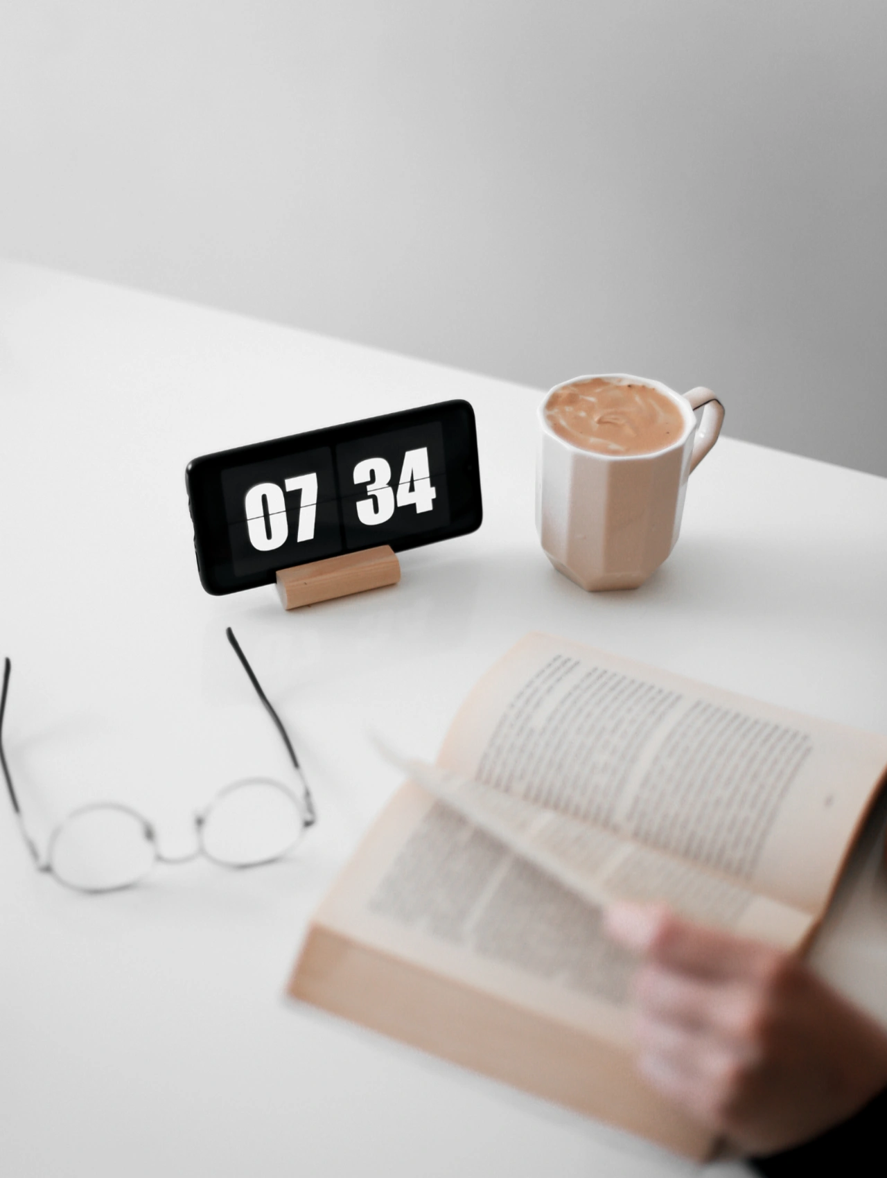 Best apps for productivity concept featuring a minimalist desk setup with a digital clock, coffee, and reading material.