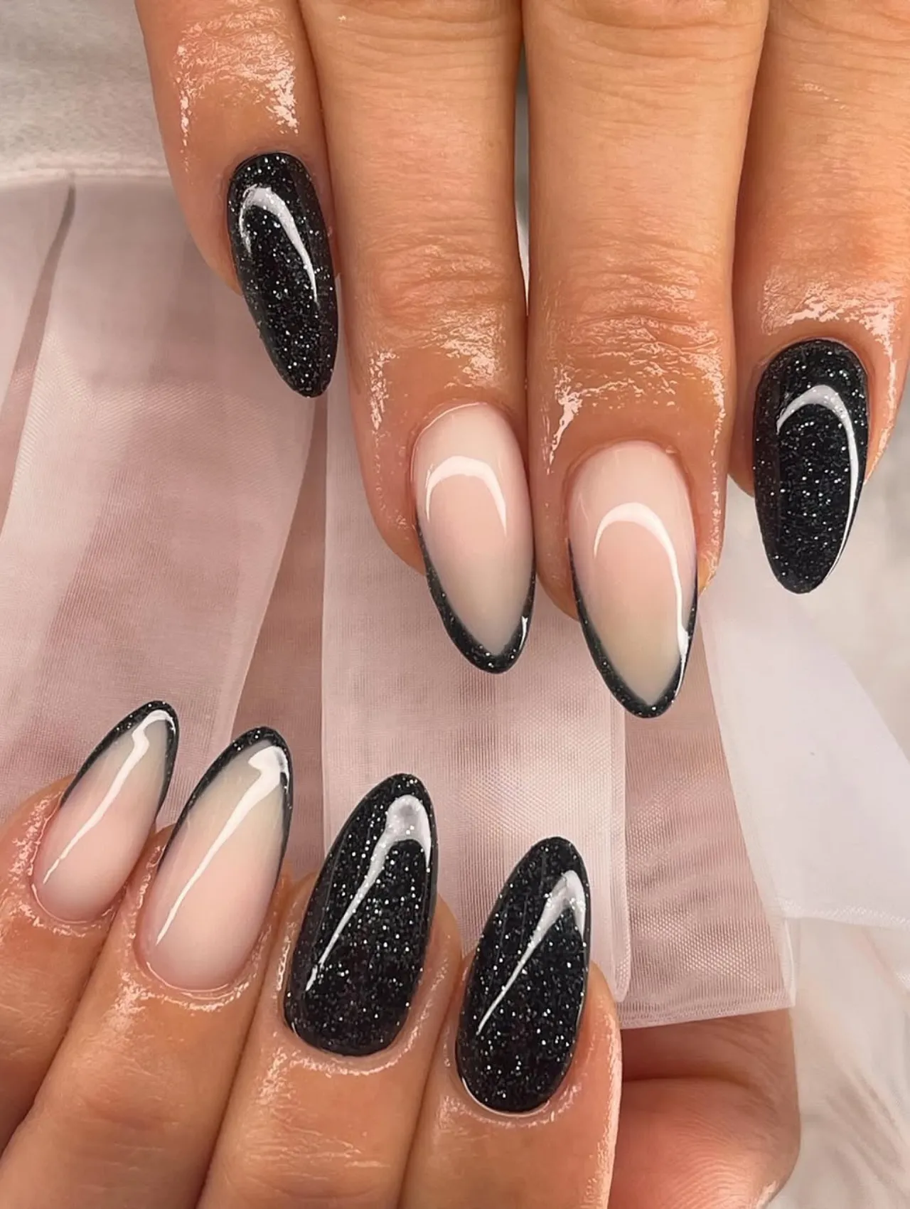 Encanto Nocturno en Negro y Brillo, uñas para Nochevieja en negro con destellos y detalles blancos.